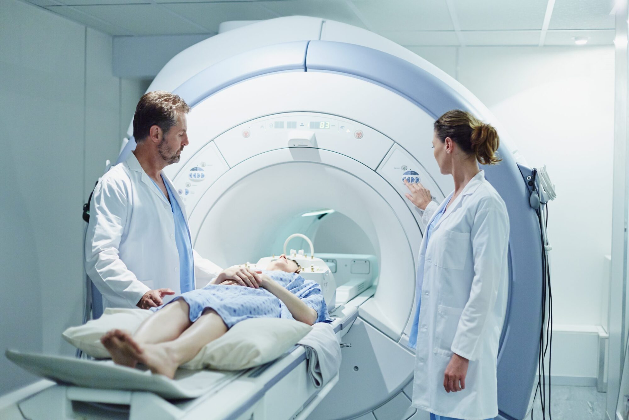 Doctors preparing patient for GE MRI scan machine